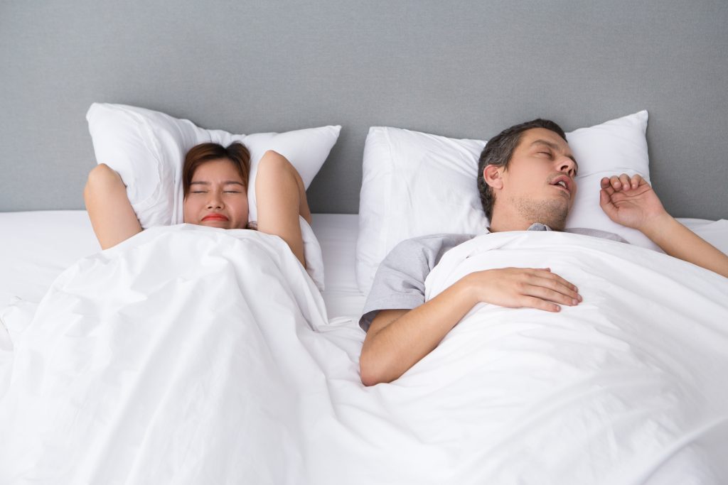 angry asian woman annoyed with husbands snoring