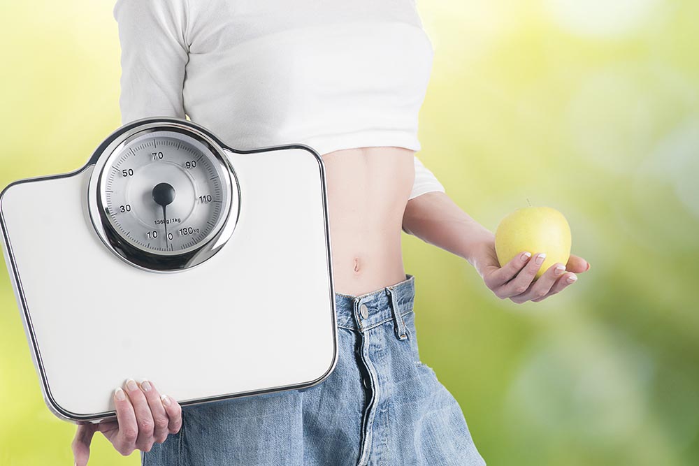 young woman with apple scales healthy diet weight loss